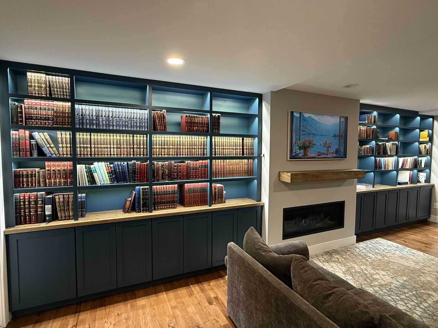 Custom library with backlit teal bookshelves and LED accent lighting